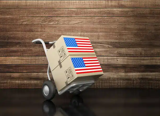 Two cardboard boxes with US flags placed on a delivery trolley ready for export