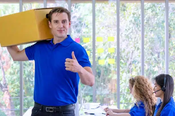 Courier giving thumbs-up with package, representing fast and reliable door-to-door delivery