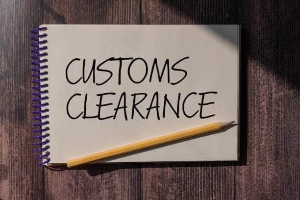 Note with “Customs Clearance” written on spiral notepad