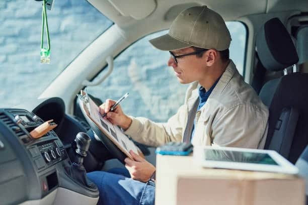 Delivery driver reviewing checklist for DDP shipping and customs clearance