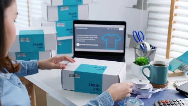 Person labeling and packing thank-you boxes for eCommerce order fulfillment via dropshipping