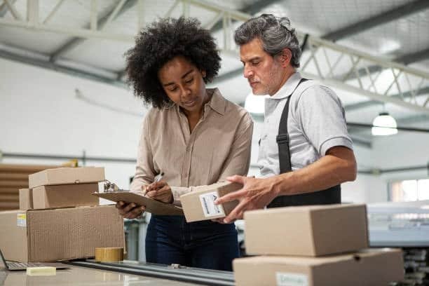 Two people verifying shipping labels and packages for dropshipping order accuracy