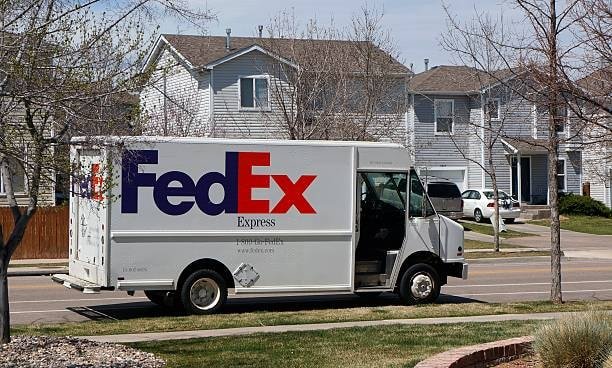 FedEx Express truck parked in a suburban residential neighborhood for home delivery