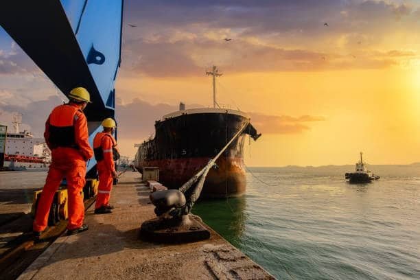 Dock workers preparing cargo vessel for FOB shipment at port