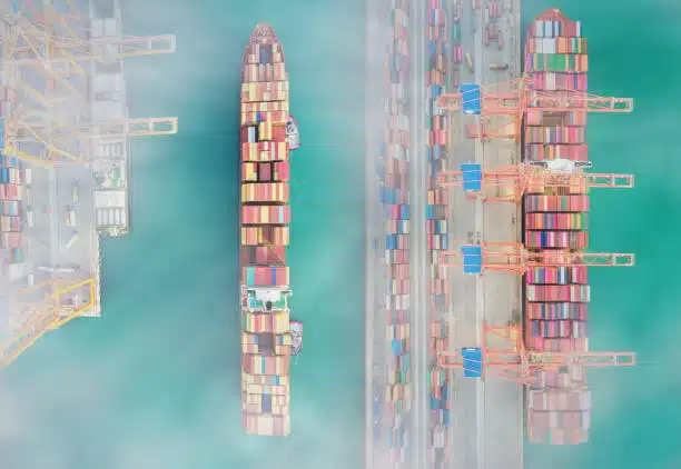 Foggy aerial photo of container ships and terminal cranes handling shipments to Singapore