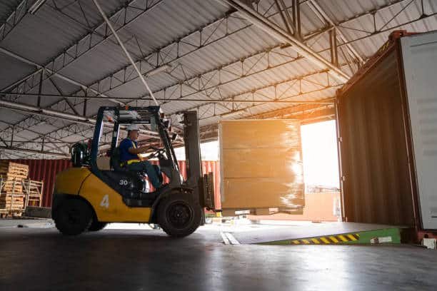 Worker using forklift to load cargo into container for shipping from China to Somalia