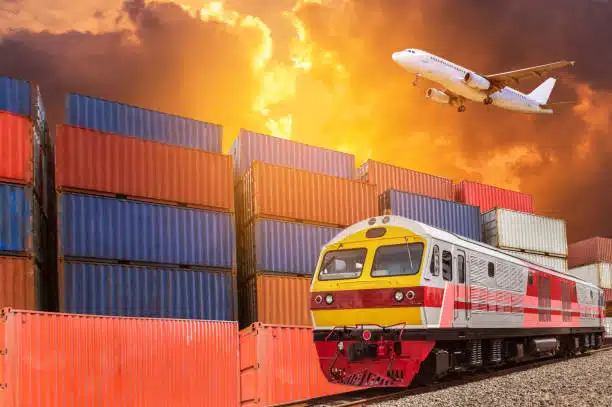 Cargo train near colorful containers and flying airplane, showcasing international freight to Greece