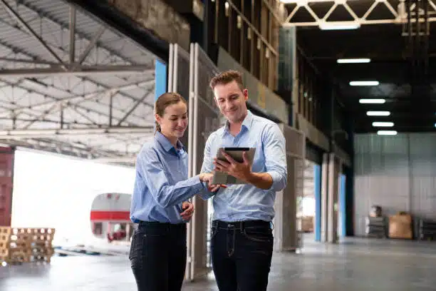 Two logistics workers coordinating shipments at a warehouse