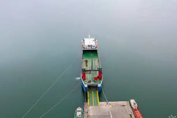 Aerial shot of a Ro-Ro cargo vessel docked at the port for vehicle transpo