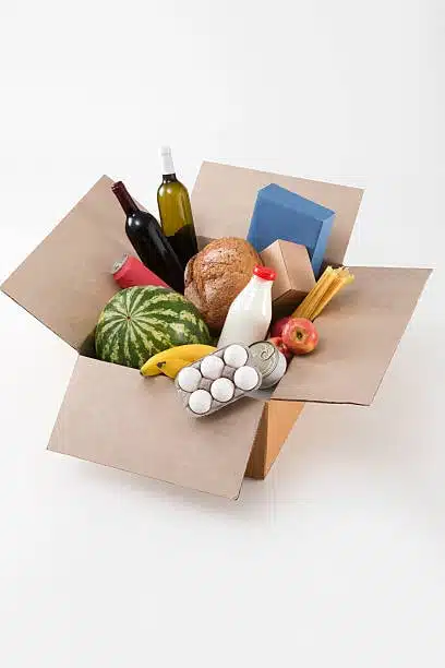 Grocery box containing both fresh and packaged perishable foods for careful shipping and delivery.