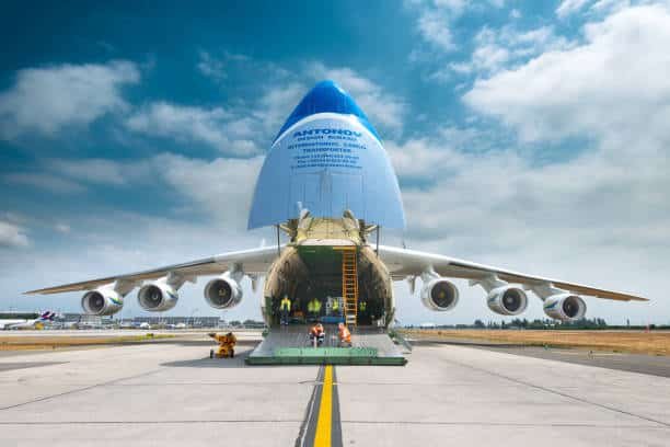 Front view of large Antonov aircraft loading freight cargo for international shipment.