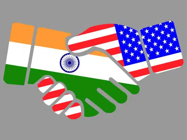 Handshake with India and USA flags symbolizing trade and shipping cooperation