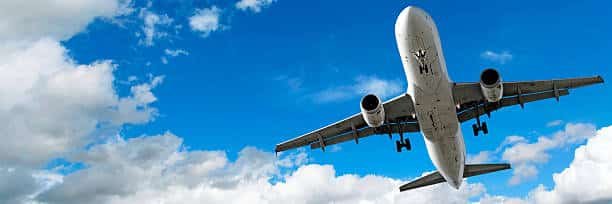 Low-angle view of an airplane taking off into a cloudy blue sky for global air freight