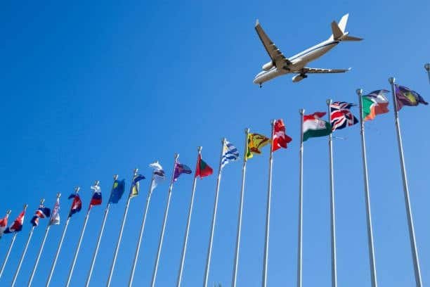 Airplane flying over international flags symbolizing global air freight shipping from China