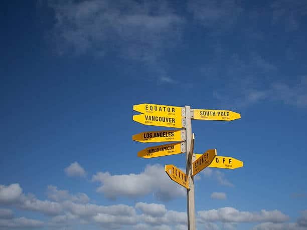 Directional sign showing global cities including Los Angeles and South Pole, symbolizing US to New Zealand shipping route