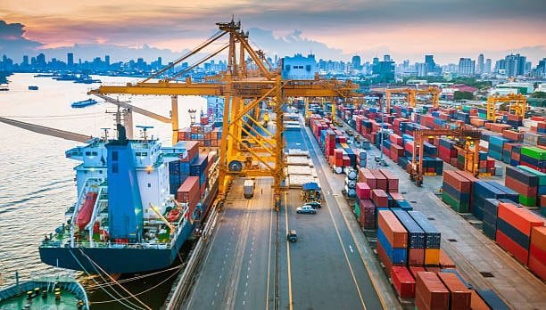 International logistics terminal with cargo ship and stacked containers at major freight port
