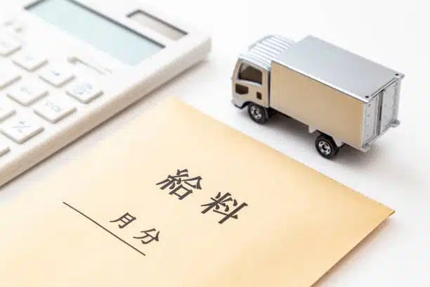 Japanese envelope labeled with shipping terms next to a calculator and toy truck