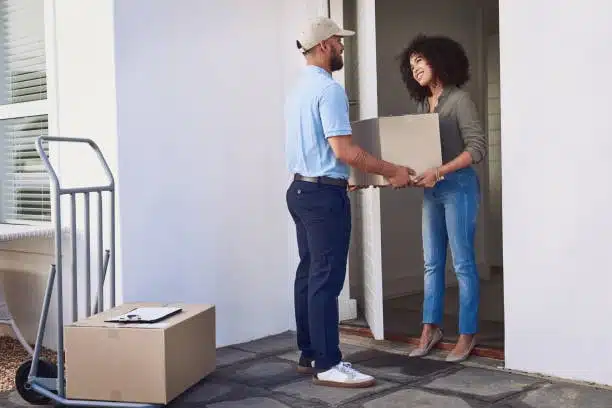 Courier handing over package to customer at doorstep for door-to-door delivery