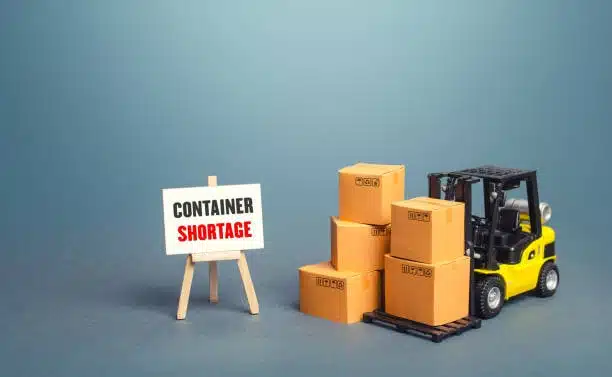 Forklift moving cargo boxes during a container shortage scenario, a challenge often addressed with LCL shipping.