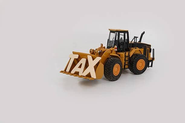 Construction vehicle carrying the word TAX to represent import duties on toys
