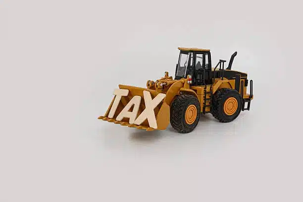Construction vehicle carrying the word TAX to represent import duties on toys