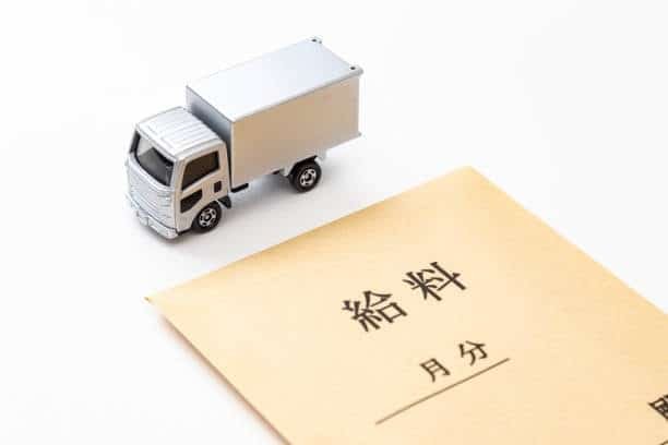 Envelope with Japanese writing and toy truck representing logistics paperwork