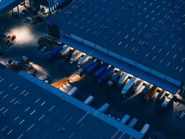 Trucks loading cargo at logistics facility for China–Libya shipments