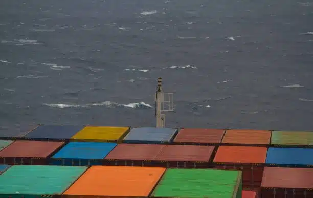 Cargo ship loaded with colorful containers representing twenty foot equivalent units