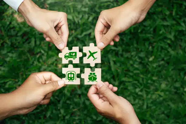 Hands assembling puzzle pieces representing truck, rail, air, and sea transport