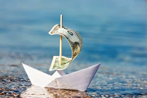 Dollar bill sailboat symbolizing sea freight costs between China and Kenya.