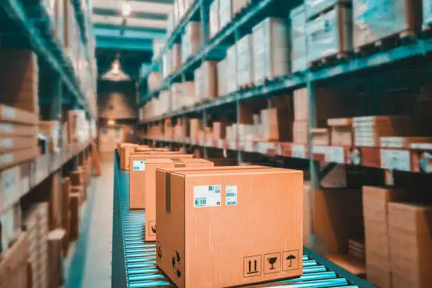 Cardboard boxes moving along a conveyor in a logistics warehouse