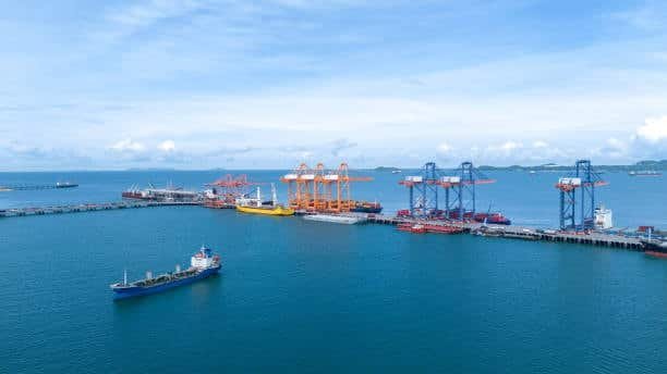 An aerial view of a busy port with cranes and ships handling cargo.