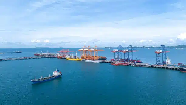 An aerial view of a busy port with cranes and ships handling cargo.