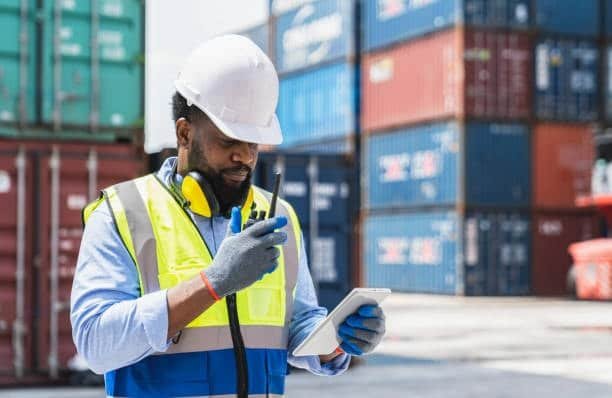 Port supervisor using radio and tablet during freight coordination