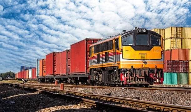 Freight train carrying cargo containers along railway route for shipment from China to Chile.