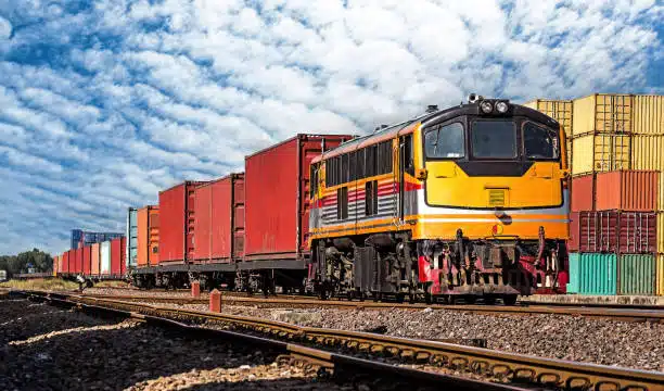 Freight train carrying cargo containers along railway route for shipment from China to Chile.
