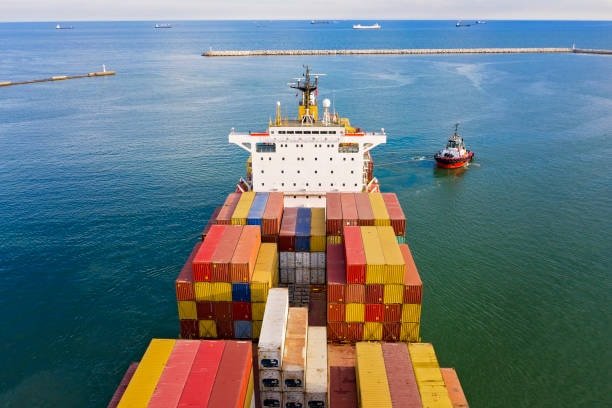 Back view of a container ship carrying goods to Singapore