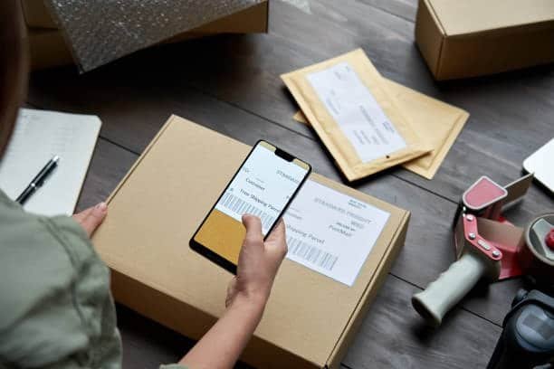 Dropshipper scanning package label using a smartphone to update tracking and delivery info