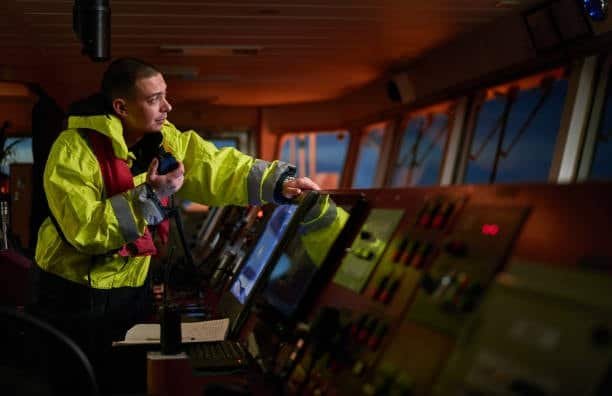 Captain navigating ship control room during ocean freight transit