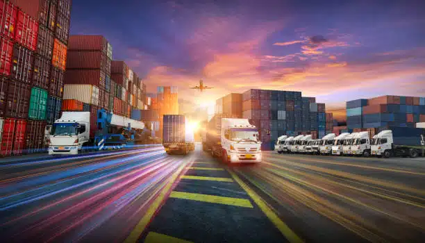 Multiple cargo trucks transporting containers at a logistics hub