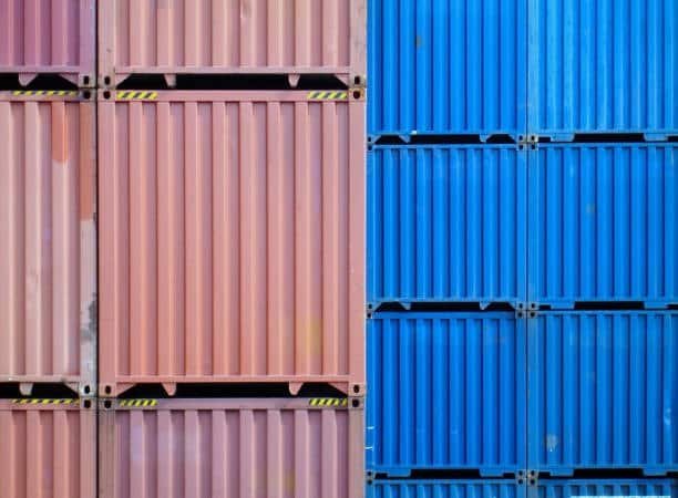 Vertical stack of red and blue cargo containers symbolizing different container ownership types