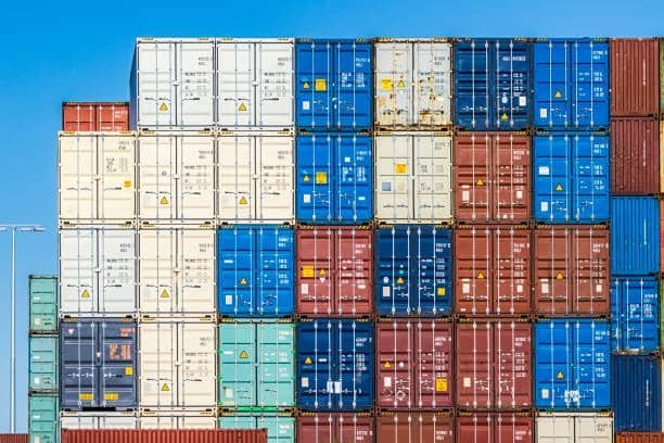 Multicolored shipping containers stacked at international freight yard