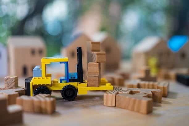 Toy forklift in a miniature wooden town representing toy distribution and import market