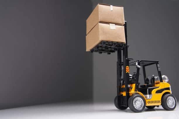 Small forklift lifting cardboard boxes symbolizing toy shipping logistics