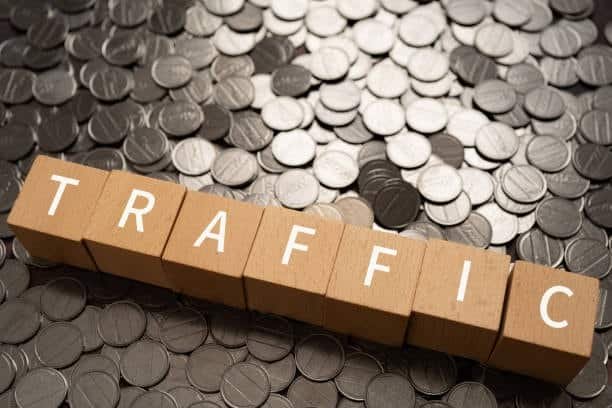 Word traffic on wooden blocks placed on coins symbolizing time and cost impact