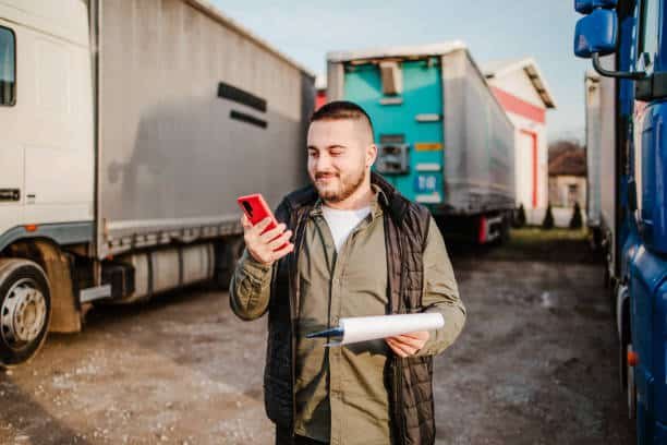 Logistics worker coordinating trucking operations via mobile device