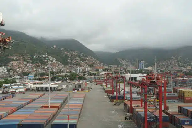Shipping containers at UAE terminal yard with mountainous backdrop, receiving imports from China.