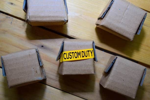 Cardboard box with custom duty label among other packages