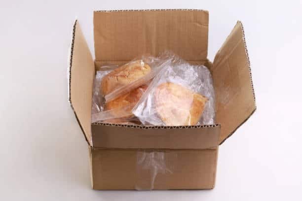 Vacuum-sealed meat products packed in a cardboard box, prepared for perishable food shipment.