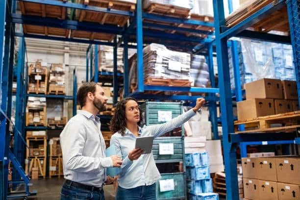 Warehouse staff reviewing inventory documentation for export shipments